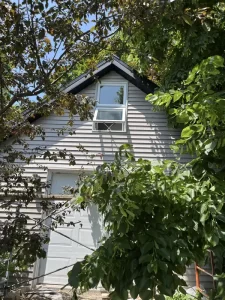 Fenêtre de grenier bien intégrée sur une façade de maison, rénovée par Construction MFA pour allier charme et performance.