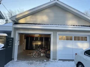 Vue extérieure d'un garage rénové en hiver avec des travaux de finition réalisés par Construction MFA.